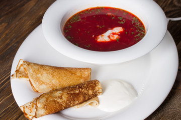 Russian soup and pancakes with sour cream