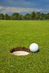 Golf, ball lying on the green next to hole