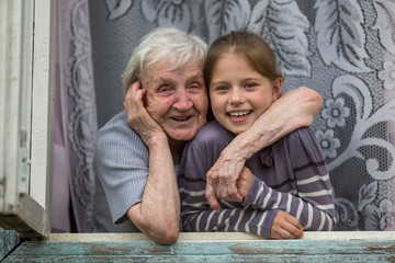 Happy grandmother and granddaughter together to look out the window.