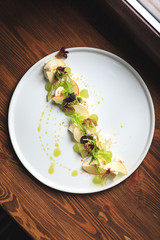 Salad is laid out diagonally on a large round dish, mozzarella, grapes, Apple, arugula and fresh Basil