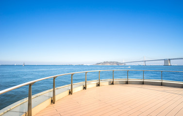 Naklejka premium empty patio with bay bridge over sea