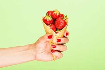 Waffle cup with strawberries in the hand