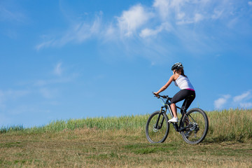 Fototapeta na wymiar Happy Young Woman riding bicycle outside