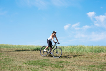 Fototapeta na wymiar Happy Young Woman riding bicycle outside
