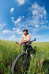 Fototapeta premium Happy Young Woman riding bicycle outside