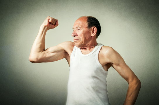 funny senior man showing the muscles
