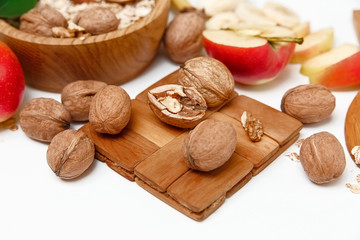 There are Banana,Apple,Orange with Walnuts in the Wooden Plate,Trivet,Healthy Fresh Organic Food on the White Background,Selective Focus