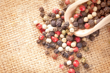 Red, white and black pepper in a spoon