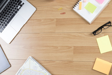 laptop, notepad and eyeglasses on wooden table