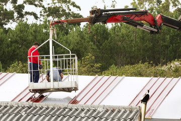 construction workers to repairing roof of building  in  crane vehicle