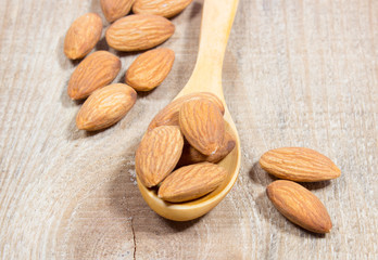 Almonds on a wooden spoon.