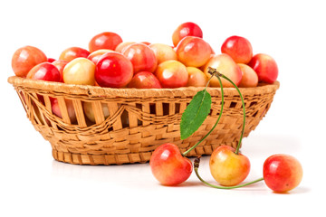 yellow cherries in a wicker basket isolated on white background