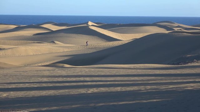 two people walking through the desert.