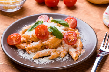 penne with tomato in brown plate