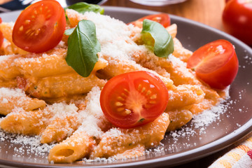 penne with tomato in brown plate