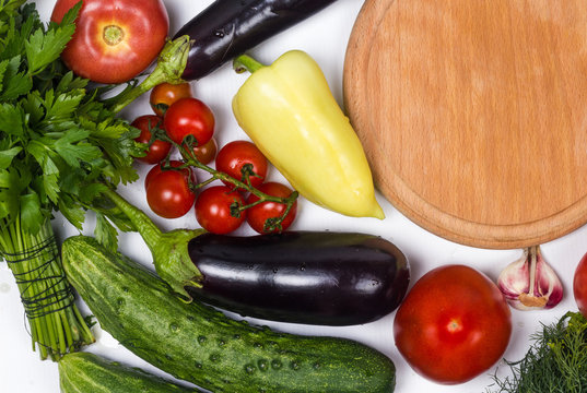 Vegetables for the background with a wooden cutting board