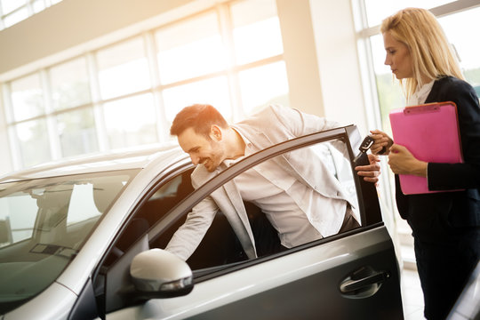 Salesperson showing vehicle to potential customer