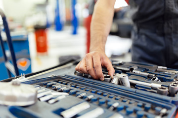 Car mechanic selecting the right tool