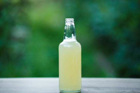 homemade lemonade in glass bottle on bokeh background