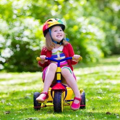 Little girl riding a tricycle