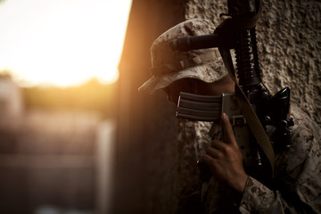 Soldier holding rifle while standing outdoors