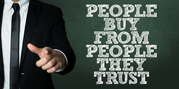 Business man pointing with the text: People Buy From People They Trust