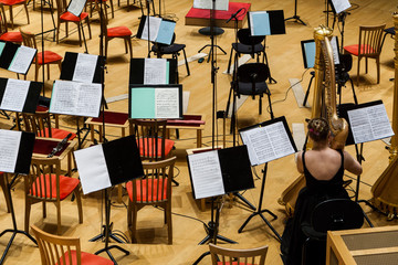 The orchestra pit in a concert hall. Chairs, musical instruments and wooden walls.