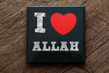 I Love ALLAH written on black note with wood background