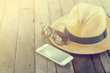 Set of vacation accessory such as mobile phone,glasses,hat  on wooden vintage background,vacation concept
