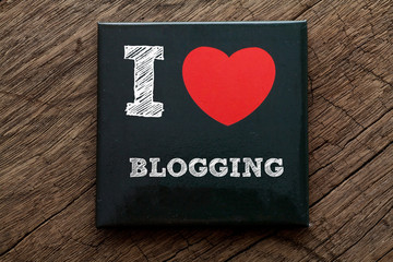I Love Blogging written on black note with wood background