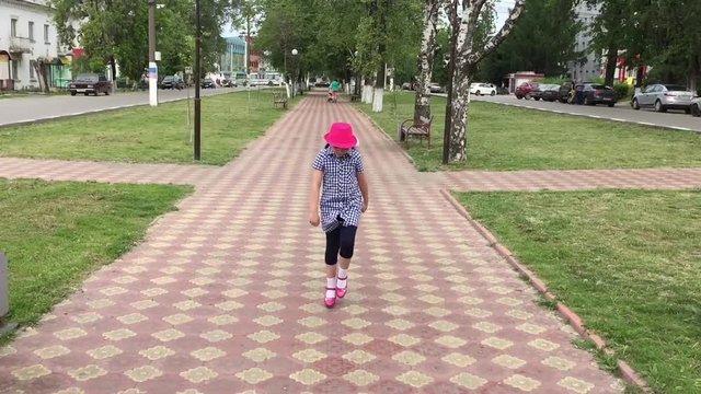 девочка играет на городской аллее