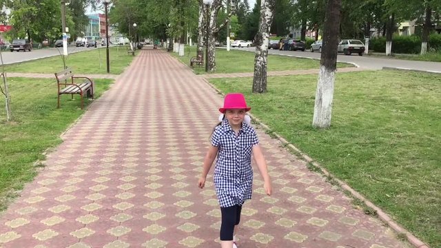 девочка играет на городской аллее