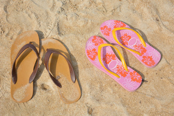 Two flip flops on a sandy ocean beach