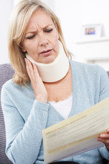 Mature Woman Reading Letter After Receiving Neck Injury