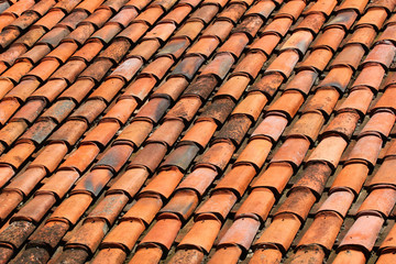 Old orange weathered roof shingles. Dirty stained ceramic tiles