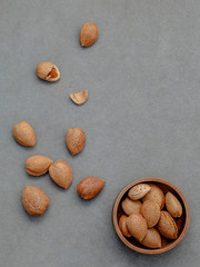 Almonds kernels and whole almonds on concrete background. Whole