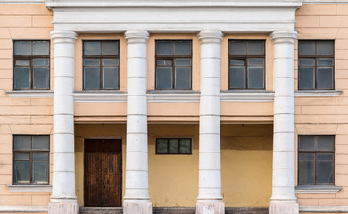 Several windows in a row on facade and portico of urban office building front view, St. Petersburg, Russia.