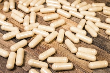 Medical pills on wooden background. Macro shot.