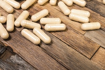 Medical pills on wooden background. Macro shot.