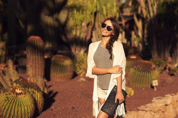 Stylish trendy beautiful girl with long braid posing in t-shirt and shorts with handbag against...
