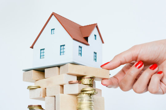 Real estate prices or crisis concept with house on pile of wooden sticks