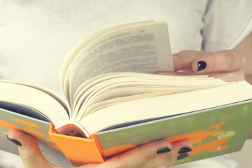 Young girl reading an  open book  old book. Books and reading are essential for self improvement, gaining knowledge and success in our careers, business and personal lives.