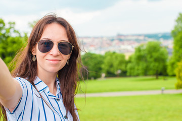 Young caucasian woman making selfie background european old city by mobile phone from the observation place