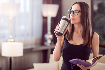 Woman dreaming and holding thermo mug
