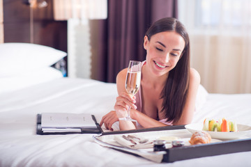 Woman drinking champagne on bed