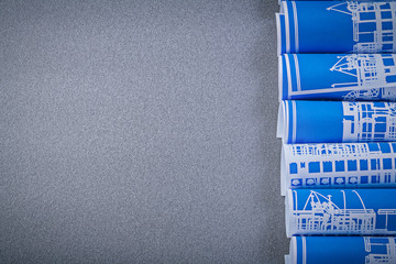 Blue rolled construction drawings on grey background copy space 