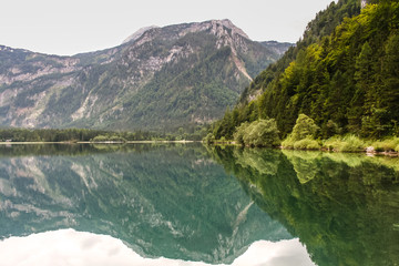 Tranquil scene of mountains and woods reflected in an Austrian lake
