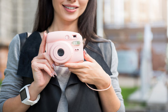 Pleasant smiling woman holding photo camera