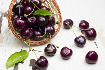 Fresh cherries.

Wicker basket full with fresh cherries on an old wooden background.
