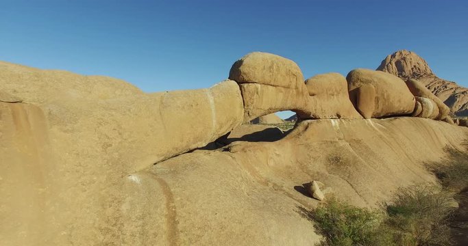 4K aerial shot flying through the granite arch of the Spitzkoppe mountains